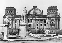 Das kriegsbeschädigte Denkmal des Kaisers Friedrich III. vor dem zerstörten Reichstagsgebäude